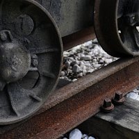 Detalle de rueda y carril de una vía de transporte de carbón.